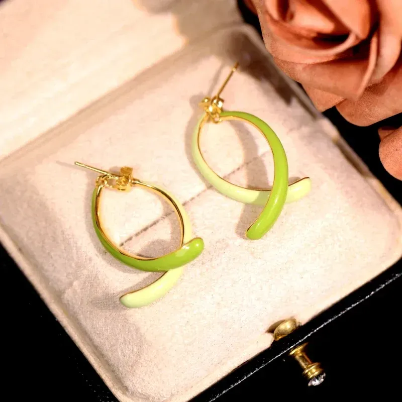 Model showcasing the dangle and style of the 14K Gold-Plated Elegant Oil Drop Fishtail Earrings