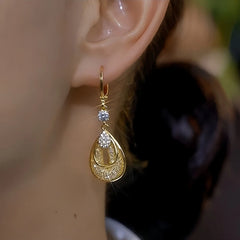 Model showcasing the dangle and style of the 14K Gold-Plated Elegant Zircon Diamond Mesh Water Drop Earrings