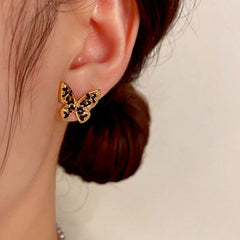 Model showcasing the dangle and style of the 14K Gold-Plated Butterfly Stud Earrings