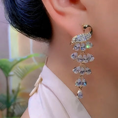 Model showcasing the dangle and style of the 14K Gold-Plated Elegant Zircon Peacock Tassel Earrings
