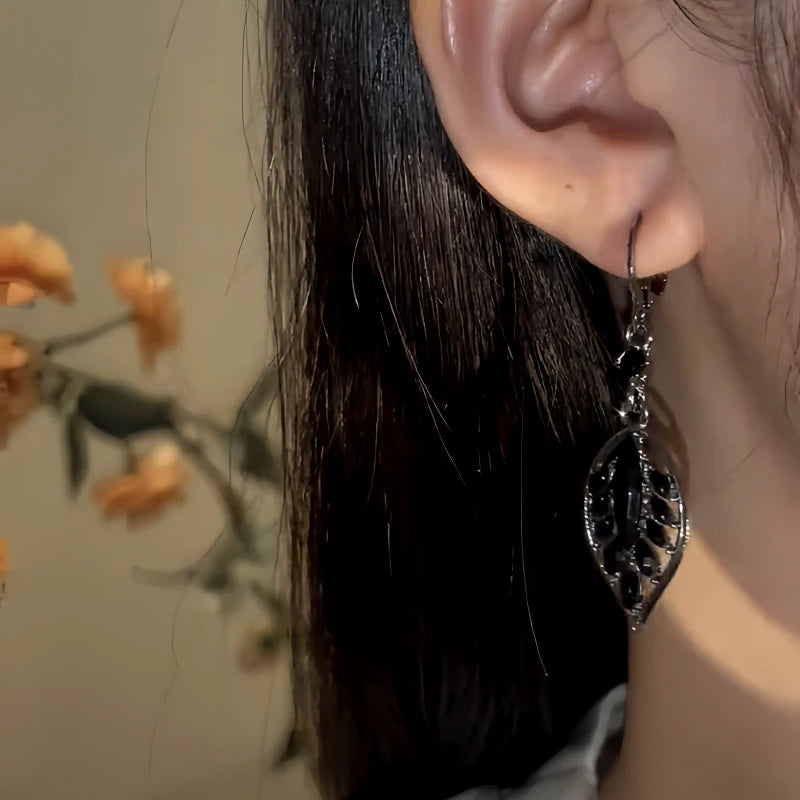 Model showcasing the dangle and style of the 14K Gold-Pated Black Zircon Leaf Tassel Earrings