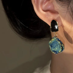 Model showcasing the dangle and style of the 14K Gold-Pated Blue Gradient Earrings