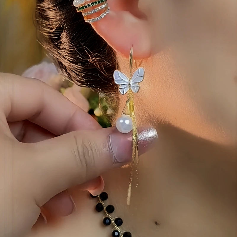 Model showcasing the dangle and style of the 14K Gold-Pated Butterfly Pearl Ear Hooks