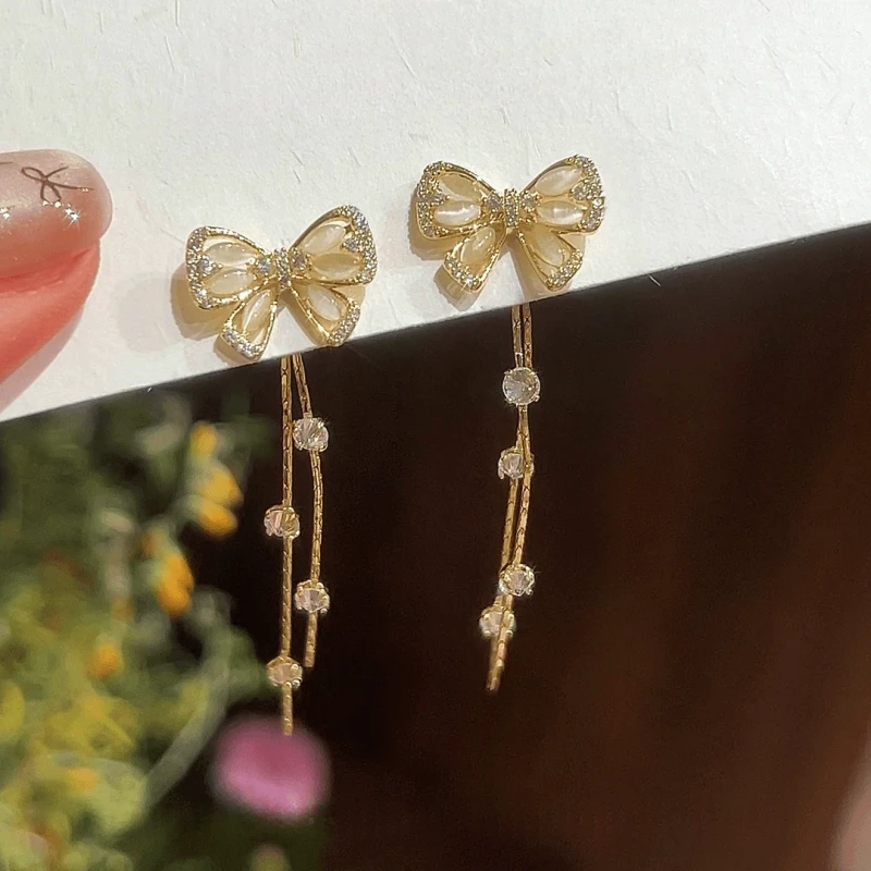Angled view of the 14K Gold-Pated Zircon Bow Tassel Earrings