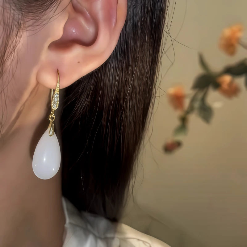 Model showcasing the dangle and style of the 14K Gold-Pated Zircon White Jade Drop Earrings