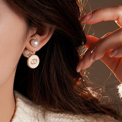 Angled view of the 14K Gold-Plated 2025 Elegant Oil Drop Round Pig Nose Bee Pearl Earrings