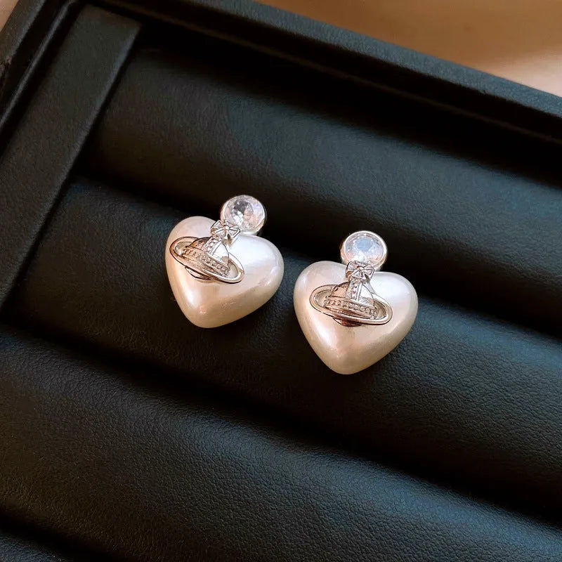 Angled view of the 14K Gold-Plated 2025 Elegant Zircon Pearl Heart Saturn Earrings