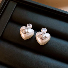 Angled view of the 14K Gold-Plated 2025 Elegant Zircon Pearl Heart Saturn Earrings