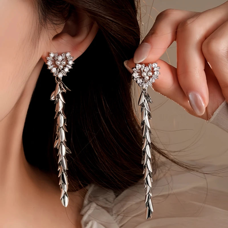 Model showcasing the dangle and style of the 14K Gold-Plated 2025 Elegant Zircon Pearl Heart Wheat Tassel Earrings