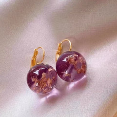 Close-up detail of the sparkling zircons and plating on the gold drop earrings