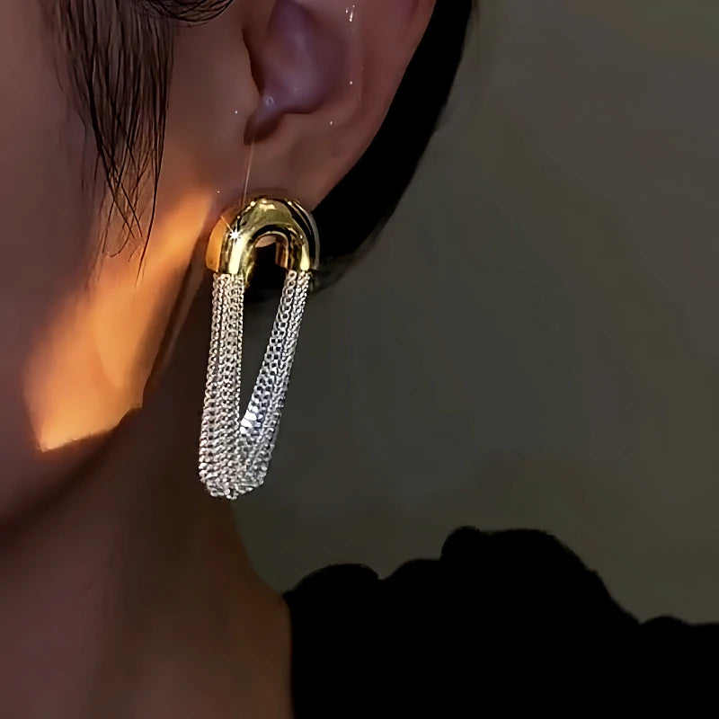 Model showcasing the dangle and style of the 14K Gold-Plated Arc Chain Tassel Earrings