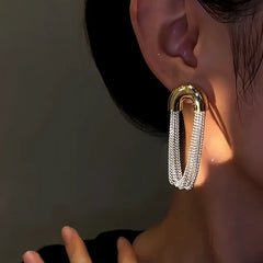 Close-up detail of the sparkling zircons and plating on the gold tassel earrings