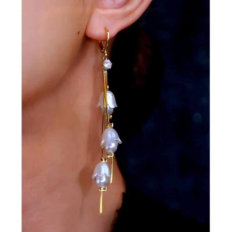 Model showcasing the dangle and style of the 14K Gold-Plated Artificial Crystal Bluebell Flower Tassel Earrings