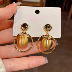 Close-up detail of the sparkling zircons and plating on the gold hoop earrings