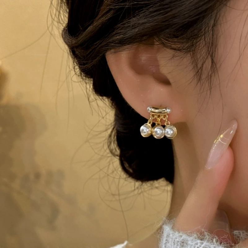 Model showcasing the dangle and style of the 14K Gold-Plated Bead Tassel Earrings