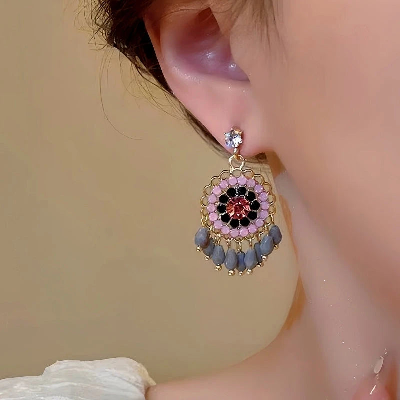 Close-up detail of the sparkling zircons and plating on the silver tassel earrings