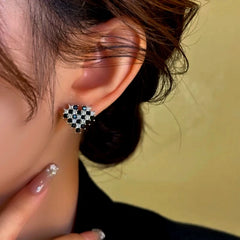 Close-up detail of the sparkling zircons and plating on the gold heart earrings