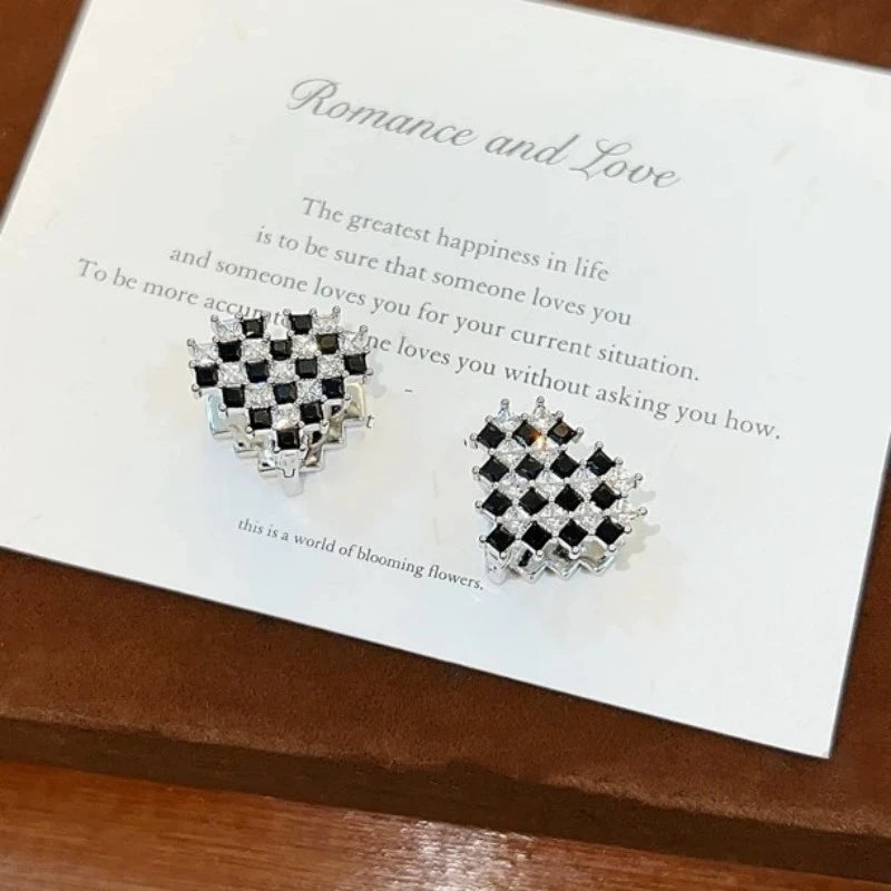 Angled view of the 14K Gold-Plated Black And White Diamond Heart Earrings