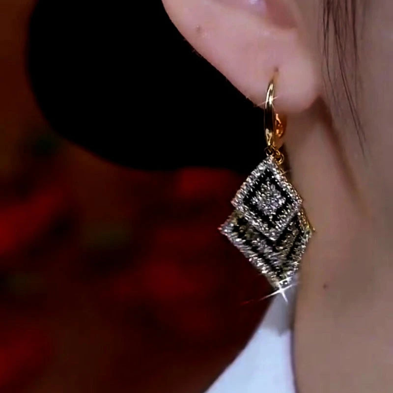 Close-up detail of the sparkling zircons and plating on the gold tassel earrings