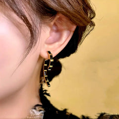 Close-up detail of the sparkling zircons and plating on the gold drop earrings