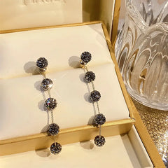 Angled view of the 14K Gold-Plated Black Diamond Long Tassel Earrings