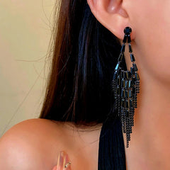 Model showcasing the dangle and style of the 14K Gold-Plated Black Diamond Tassel Earrings