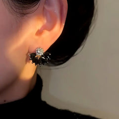 Model showcasing the dangle and style of the 14K Gold-Plated Black Zircon Flower Earrings