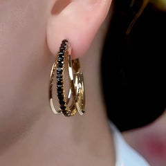 Model showcasing the dangle and style of the 14K Gold-Plated Black Zircon Hoop Earrings
