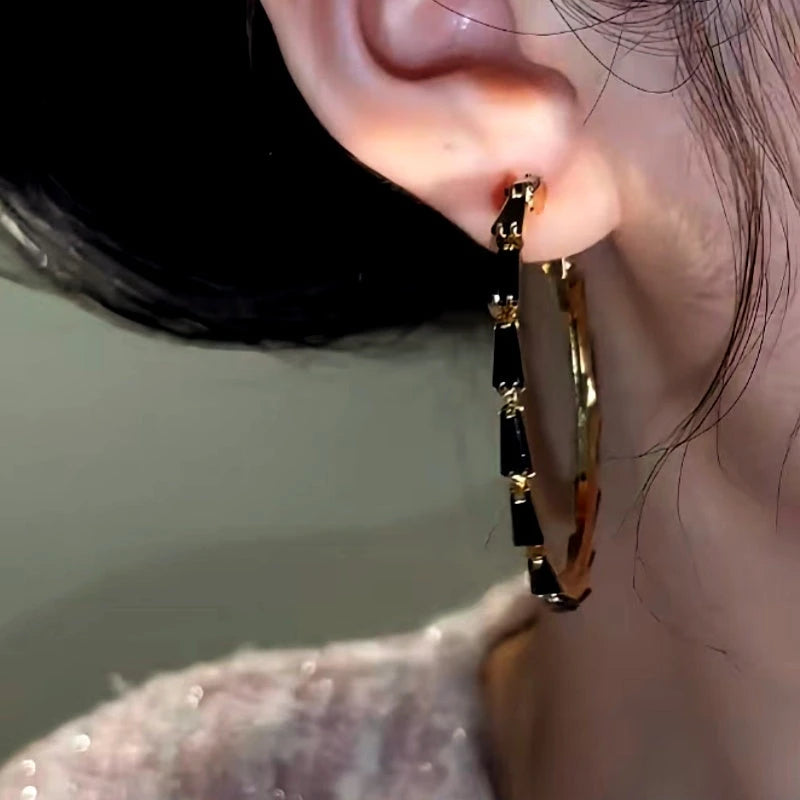 Close-up detail of the sparkling zircons and plating on the Black Hoop Earrings