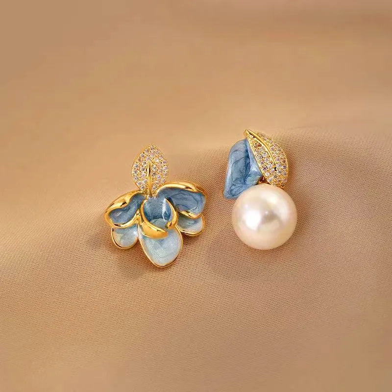 Model showcasing the dangle and style of the 14K Gold-Plated Blue Camellia Pearl Earrings