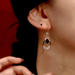 Model showcasing the dangle and style of the 14K Gold-Plated Blue Crystal Water Drop Ear Hook Earrings