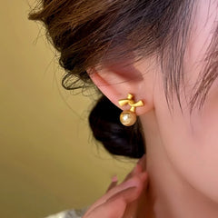 Model showcasing the dangle and style of the 14K Gold-Plated Bow Bead Earrings