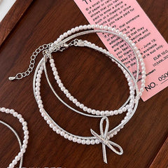 Close-up of the pendant and clasp on the Bow Pearl Necklace