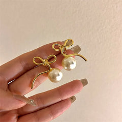 Angled view of the 14K Gold-Plated Bow Pearl Earrings
