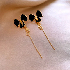 Angled view of the 14K Gold-Plated Bow Tassel Earrings