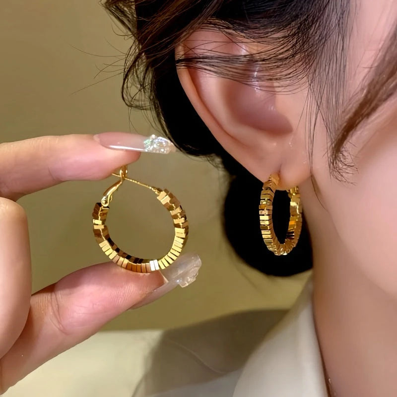 Model showcasing the dangle and style of the 14K Gold-Plated Broken Diamond Hoop Earrings