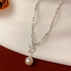 Detailed view of the 14K Gold-Plated Broken Silver Zircon Leaf Pearl Necklace chain and pendant