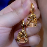 Pair of gold champagne crystal drop earrings held in hand