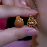 Reversible gold teardrop earrings: smooth caramel and tiered textured sides, held between fingers