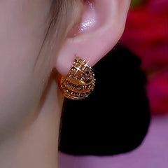 Model showcasing the dangle and style of the 14K Gold-Plated Brown Diamond And Oil Drop Double-Sided Basket Earrings