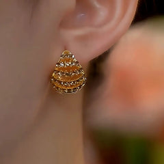 Model showcasing the dangle and style of the 14K Gold-Plated Brown Diamond Double-Sided Basket Ear Buckle Earrings
