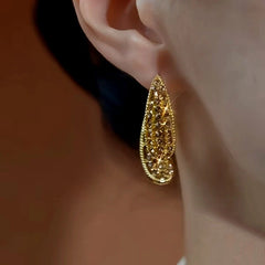 Model showcasing the dangle and style of the 14K Gold-Plated Brown Diamond Earrings