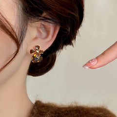 Brown flower amber crystal drop earring worn on woman's ear, front angle view