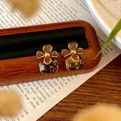 Women's brown floral drop earrings with faceted amber crystal and gold detailing