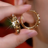 Pair of women's gold brown crystal hoop earrings held in hand, sparkly front and clasp back