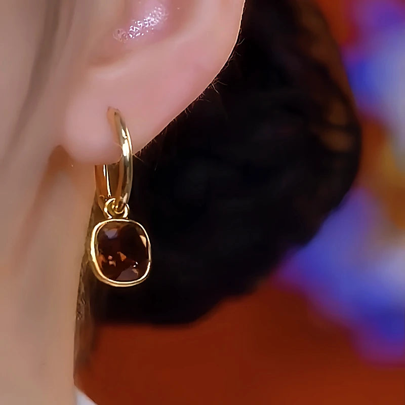 Model showcasing the dangle and style of the 14K Gold-Plated Brown Diamond Oil Drop Earrings