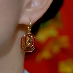 Model showcasing the dangle and style of the 14K Gold-Plated Brown Diamond Red Retro Square Earrings
