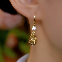 Model showcasing the dangle and style of the 14K Gold-Plated Brown Diamond Water Drop Earrings