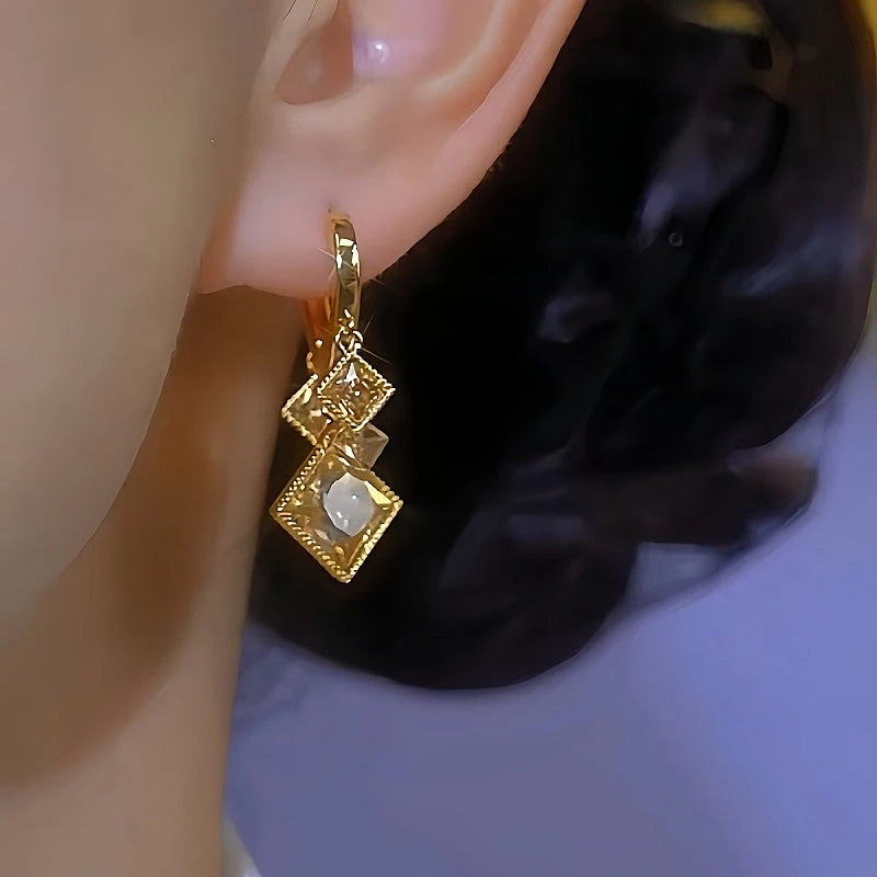 Model showcasing the dangle and style of the 14K Gold-Plated Brown Zircon Crystal Diamond Earrings