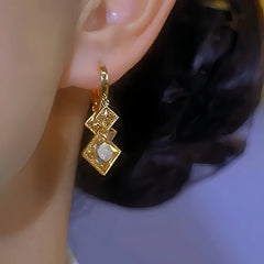 Model showcasing the dangle and style of the 14K Gold-Plated Brown Zircon Crystal Diamond Earrings